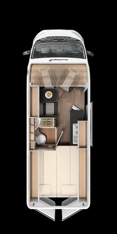 the interior of a small motor home on display in a dark room with wood flooring