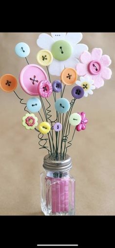 a vase filled with lots of different colored buttons