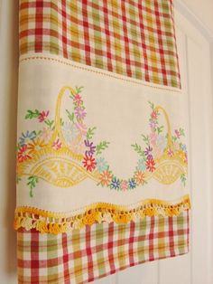 a kitchen towel hanging on the side of a white door with flowers and baskets in it