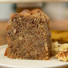 a close up of a piece of cake on a plate with bananas in the background