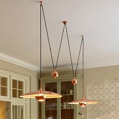 three lights hanging from the ceiling in a kitchen