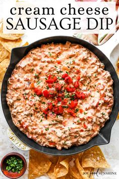 a skillet filled with cream cheese sausage dip surrounded by tortilla chips and tomatoes