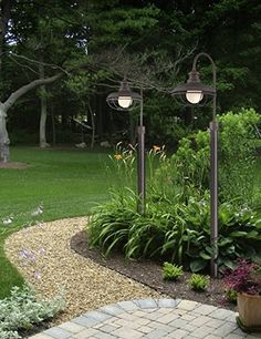 a garden with lots of plants and lights in it's center area on a brick walkway