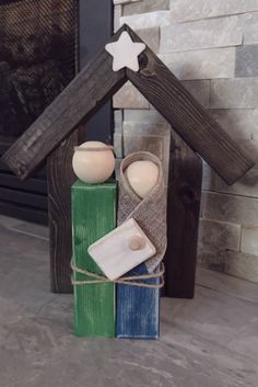 a nativity scene made out of wood blocks with candles in the shape of a house