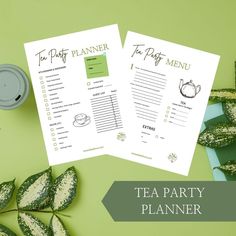 two tea party menus sitting on top of a green table next to some leaves