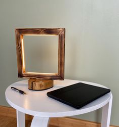 a desk with a laptop, mirror and pen on it