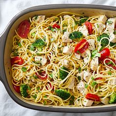 a casserole dish with chicken, broccoli, and tomatoes in it