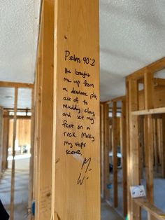 a wooden pole with writing on it in the middle of a room that is being built