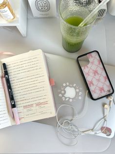 an apple laptop computer sitting on top of a desk next to a cup and headphones