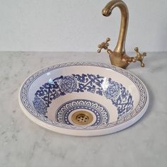 a sink that is sitting on top of a marble counter with a faucet