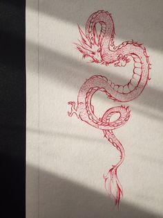 a drawing of a red dragon on white paper