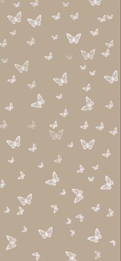 white butterflies are flying in the air on a brown background, and there is no image to describe