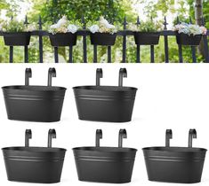 six black tubs with handles and flowers in them