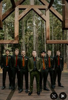 a group of young men standing next to each other in front of a wooden structure