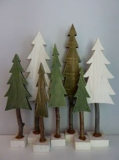 small wooden trees are lined up against a wall