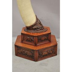 an antique wooden box with a carved foot on top