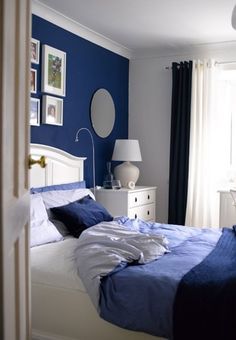 a bedroom with blue walls and white furniture