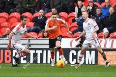 soccer players in action on the field during an orange and white game, with spectators watching