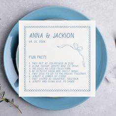 a blue plate topped with a menu on top of a white table next to flowers