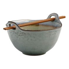 a bowl with two chopsticks in it and a wooden handle on the side