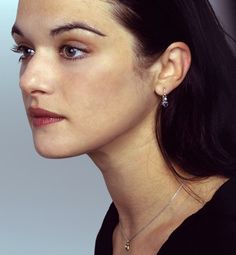 a close up of a person wearing a necklace and earring on her left ear