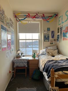 a bed room with a neatly made bed and lots of pictures hanging on the wall