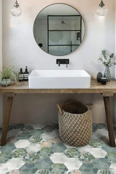 a bathroom with a sink and mirror on the wall next to a wooden bench in front of a tiled floor