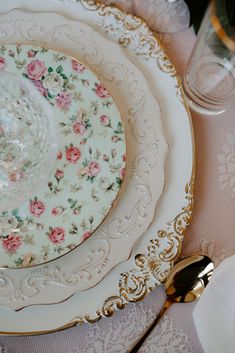 an ornately decorated china plate with gold trimmings and pink flowers on it