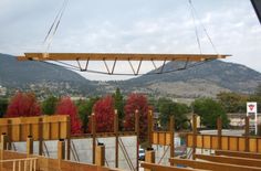 an unfinished building being constructed with wooden beams and wood slats hanging from the ceiling