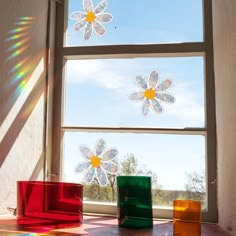 the sun shines brightly through three windows with flowers in them and on top of each other