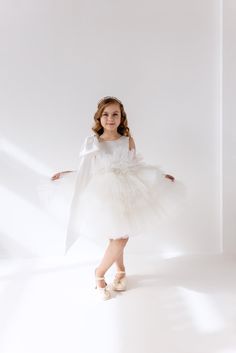 Presenting the White Flower Girl Dress, a delightful and charming ensemble that is perfect for a toddler wedding guest or junior bridesmaid. This enchanting dress features a voluminous and puffy tulle tutu skirt, creating a whimsical and fairy-tale-like silhouette. The beautiful big bow detail adds a touch of elegance and playfulness, making it an ideal choice for a communion, baptism, birthday celebration, or any special occasion. The cotton lining ensures comfort for the little one, while the V-shaped open back adds a hint of sophistication and modernity to the design. Whether it's for a wedding party or a reception, this dress is a timeless and versatile option for the young fashionista, ensuring she feels like a princess on the big day. Detachable bow from organza Design Customisation: Dress With Big Bow, Tutu En Tulle, Bridesmaid Tulle, Enchanting Dress, Tulle Tutu Skirt, White Flower Girl Dresses, Baptism Dress, Tulle Tutu, Big Bow