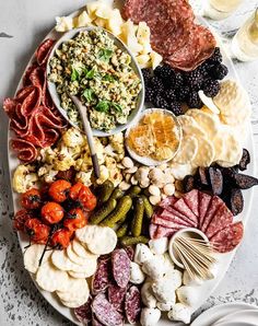 a platter filled with meats, vegetables and other foods on top of a table