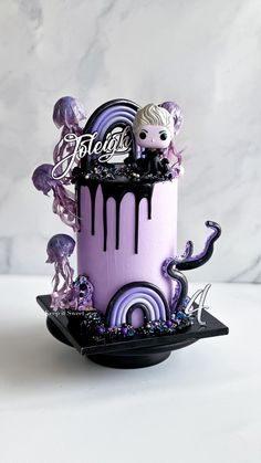 a purple and black cake with an octopus on top