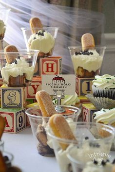 cupcakes and pastries are on display in plastic cups