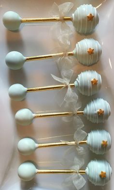 six white and gold cake pops with star decorations on them, lined up in a row