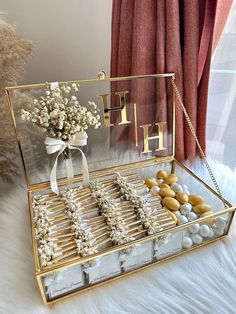 a box filled with candies and flowers on top of a white furnishing