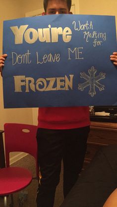 a man holding up a sign that says you're don't leave me frozen