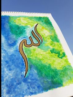 an arabic calligraphy written in gold on a green and blue watercolored background