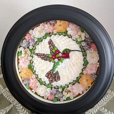 a cake decorated with flowers and a humming bird