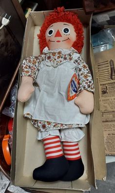 an old raggedy doll in a cardboard box