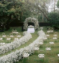 an outdoor ceremony setup with white flowers and chairs