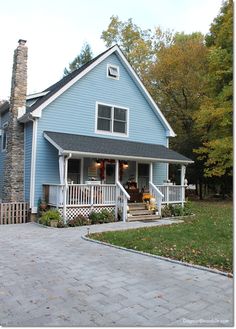 a blue house with white porch and stairs