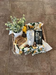 a basket filled with lots of different items on top of a tile floor next to a potted plant