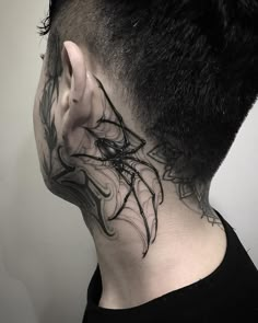 a man's neck tattoo with spider webs on the back of his head