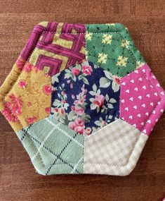 a colorful patchwork pot holder sitting on top of a wooden table