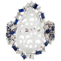 This beautiful ring is cast in 18 Karat white gold. It is hand set in 3.83 carats Jade, .81 carats blue sapphire and .86 carats of diamonds. FOLLOW MEGHNA JEWELS storefront to view the latest collection & exclusive pieces. Meghna Jewels is proudly rated as a Top Seller on 1stDibs with 5 star customer reviews. All items manufactured by us are handmade and can be customized or redesigned. Composition Size-23X17X29 MM Total Weight-7.76 Gold Weight(Gms)-6.66 Diamond Wt(Cts)-0.86 Jade Wt(Cts)-3.83 Blue Sapphire Wt(Cts)-0.81