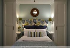 a bedroom with blue walls and white bedding