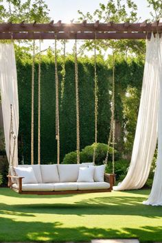 Wooden swing with white cushions suspended by ropes under a pergola with white curtains in a lush garden. Backyard Swing Ideas, Villa Inspiration, Porch Swing Plans, Backyard Hangout, Reading Garden