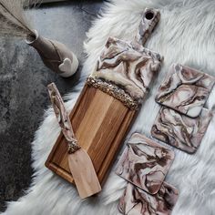 a wooden cutting board sitting on top of a white fur covered floor next to other items