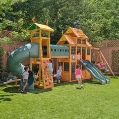 children playing in a backyard with a large wooden play set and slide, surrounded by green grass